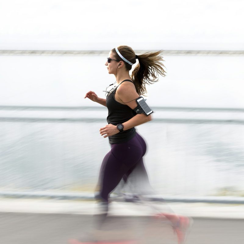 woman running on the boardwalk in a park
